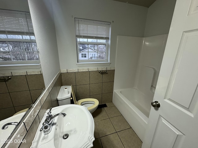 1003 Orchard St, Carthage, MO 64836 - full bath with tile walls, plenty of natural light, tile patterned flooring, a wainscoted wall, and shower / tub combination