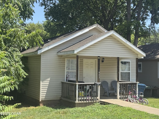 1003 Orchard St, Carthage, MO 64836 - bungalow-style house featuring covered porch and a shingled roof