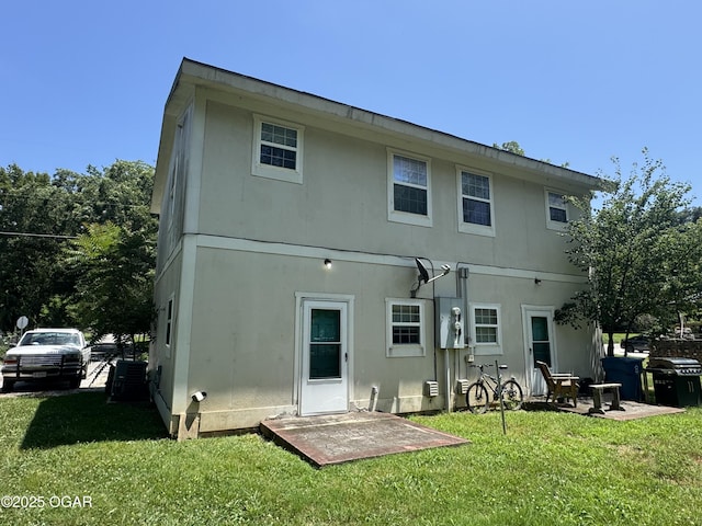 1003 Orchard St, Carthage, MO 64836 - rear view of house with a yard and stucco siding