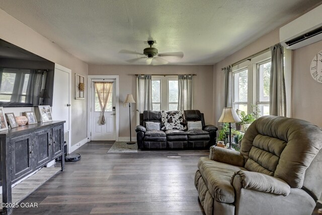 605 SE 10th Ln, Lamar, MO 64759 - living area featuring a wall unit AC, a ceiling fan, plenty of natural light, dark wood finished floors, and a textured ceiling