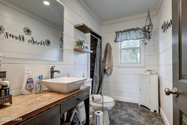 605 SE 10th Ln, Lamar, MO 64759 - bathroom featuring stone finish flooring, vanity, and a shower with shower curtain