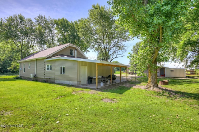 605 SE 10th Ln, Lamar, MO 64759 - view of side of property with a yard, a patio area, and a carport