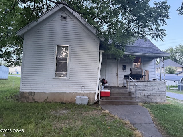 1222 Jersey St, Carthage, MO 64836 - bungalow-style house featuring a porch, a front lawn, and a shingled roof