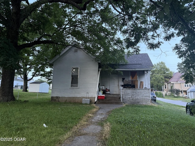 1222 Jersey St, Carthage, MO 64836 - view of front of home with a porch, a front yard, and a shingled roof