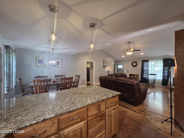 3009 S Monroe Ave, Joplin, MO 64804 - kitchen with a ceiling fan, lofted ceiling, light stone countertops, hanging light fixtures, and dark tile patterned floors