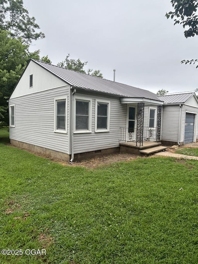 419 Depot St, Oswego, KS 67356 - ranch-style house with a garage, a front yard, and a metal roof