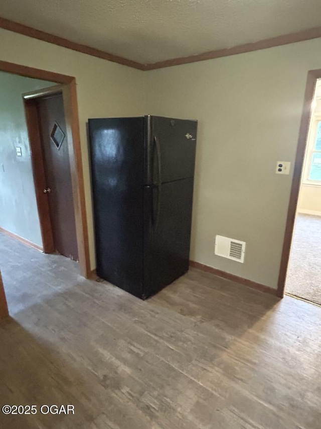 419 Depot St, Oswego, KS 67356 - kitchen featuring freestanding refrigerator, light wood-type flooring, and crown molding
