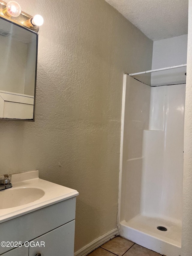 821 New Hampshire Ave, Joplin, MO 64801 - full bathroom with vanity, a shower, tile patterned flooring, a textured ceiling, and a textured wall