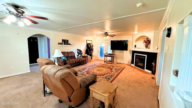 4950 SE 118th St, Galena, KS 66739 - living room with a ceiling fan, light colored carpet, crown molding, arched walkways, and a fireplace