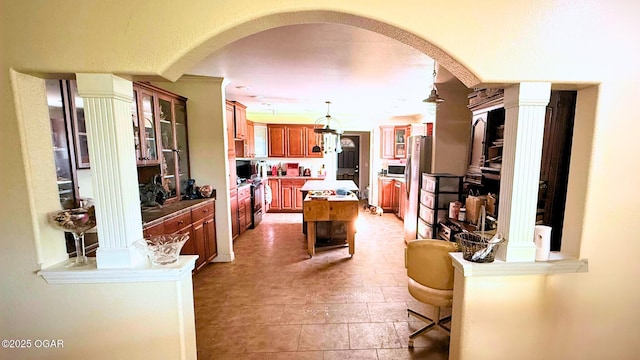 4950 SE 118th St, Galena, KS 66739 - kitchen with freestanding refrigerator, arched walkways, a kitchen island, brown cabinets, and glass insert cabinets
