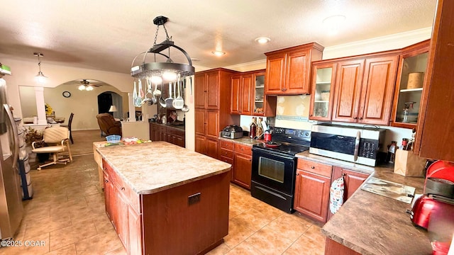 4950 SE 118th St, Galena, KS 66739 - kitchen featuring black range with electric cooktop, stainless steel microwave, a center island, brown cabinetry, and ceiling fan