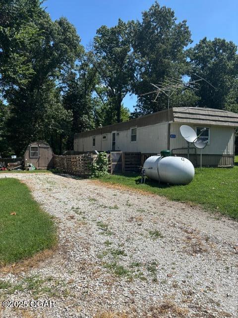 8305A Ivory Rd, Reeds, MO 64859 - view of home's exterior with a storage shed