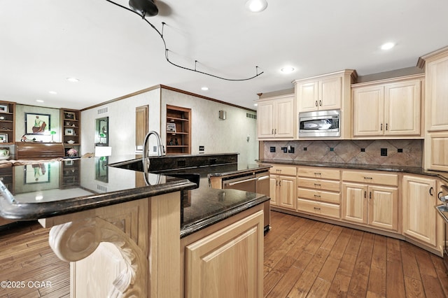 5623 Rivercrest Valley Dr, Joplin, MO 64804 - kitchen with stainless steel microwave, crown molding, light wood-style flooring, tasteful backsplash, and light brown cabinets