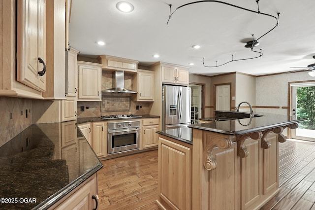 5623 Rivercrest Valley Dr, Joplin, MO 64804 - kitchen with appliances with stainless steel finishes, wall chimney range hood, light wood-type flooring, a kitchen breakfast bar, and ornamental molding