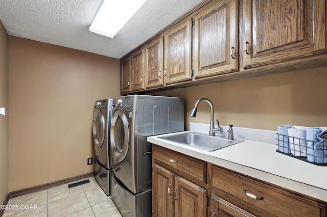 5623 Rivercrest Valley Dr, Joplin, MO 64804 - washroom featuring cabinet space, washer and clothes dryer, light tile patterned flooring, and a textured ceiling