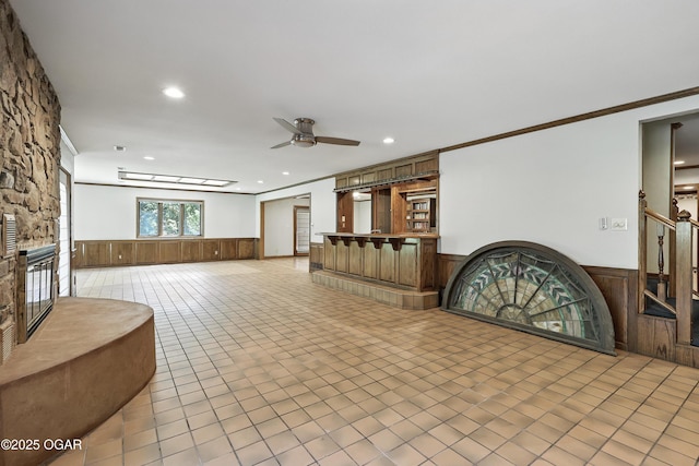 5623 Rivercrest Valley Dr, Joplin, MO 64804 - welcome area with wainscoting, a ceiling fan, recessed lighting, crown molding, and a fireplace