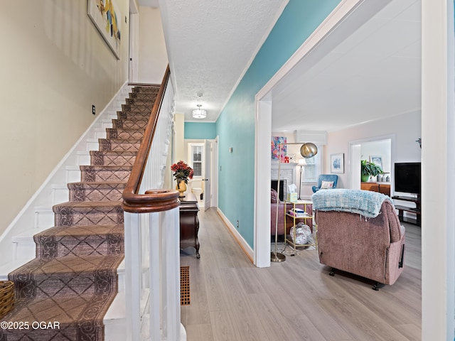 629 W Islington Pl, Joplin, MO 64801 - stairs with wood finished floors, a fireplace, a textured ceiling, and crown molding