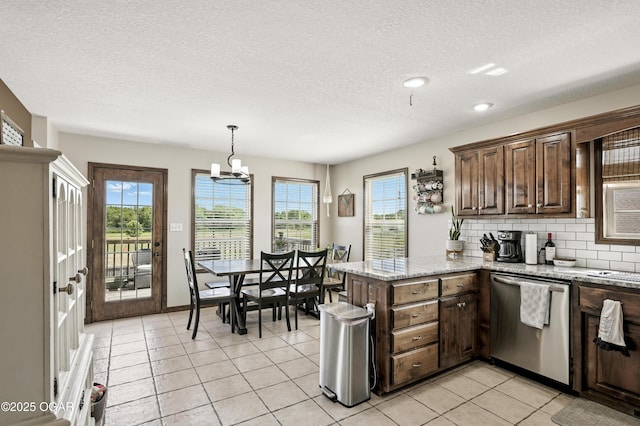 2256 N Greystone Sq, Webb City, MO 64870 - kitchen with stainless steel dishwasher, a textured ceiling, a peninsula, plenty of natural light, and backsplash