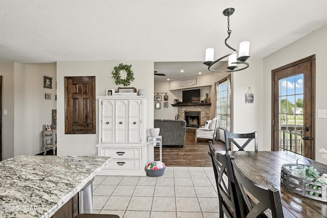 2256 N Greystone Sq, Webb City, MO 64870 - dining area with a fireplace, light tile patterned floors, a chandelier, and recessed lighting