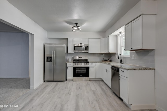 233 Timber Ln, Carl Junction, MO 64834 - kitchen featuring stainless steel appliances, white cabinets, tasteful backsplash, stone countertops, and light wood finished floors