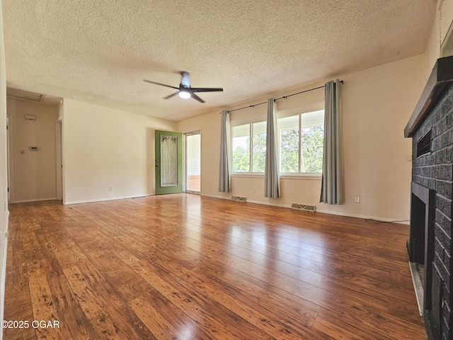 2507 N Ozark Ave, Joplin, MO 64801 - unfurnished living room with a fireplace, ceiling fan, wood-type flooring, and a textured ceiling
