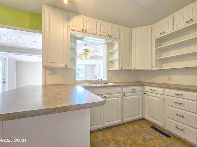 2507 N Ozark Ave, Joplin, MO 64801 - kitchen with open shelves, white cabinets, ceiling fan, and a peninsula