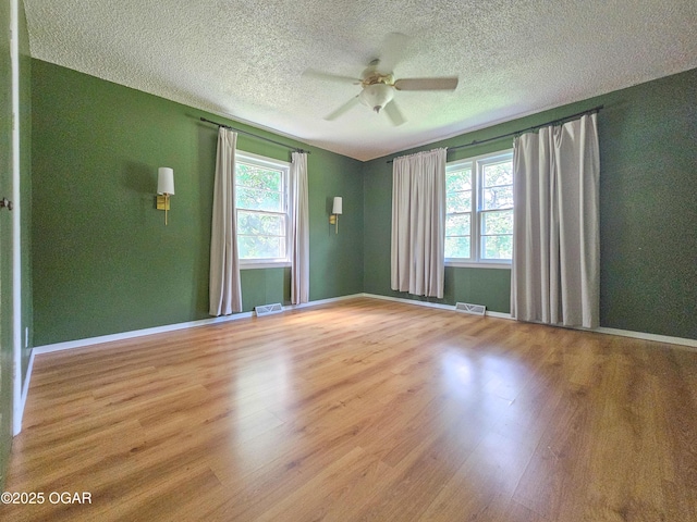 2507 N Ozark Ave, Joplin, MO 64801 - unfurnished room with plenty of natural light, wood finished floors, a ceiling fan, and a textured ceiling
