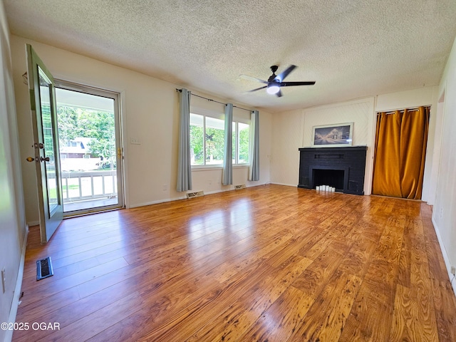 2507 N Ozark Ave, Joplin, MO 64801 - unfurnished living room with a fireplace, ceiling fan, a textured ceiling, and wood finished floors