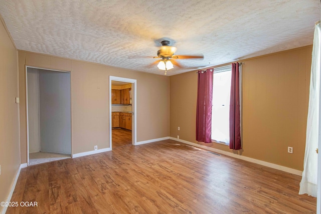 400 Broadway St, Lamar, MO 64759 - spare room with a ceiling fan, light wood-type flooring, and a textured ceiling