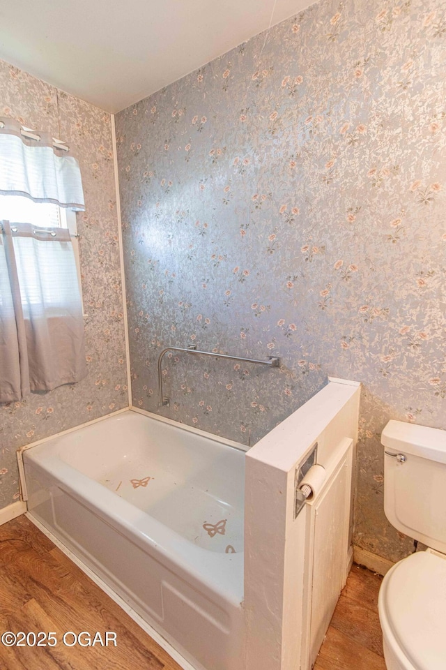 400 Broadway St, Lamar, MO 64759 - bathroom featuring a tub to relax in, wood finished floors, and wallpapered walls