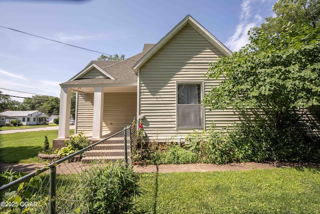 400 Broadway St, Lamar, MO 64759 - view of front facade featuring a front yard, a shingled roof, and covered porch