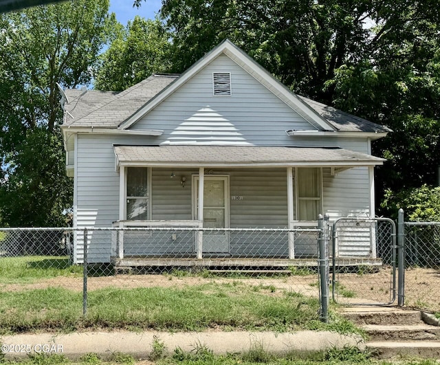 1301 S Pennsylvania Ave, Joplin, MO 64801 - view of front of house featuring covered porch, a shingled roof, a fenced front yard, and a gate