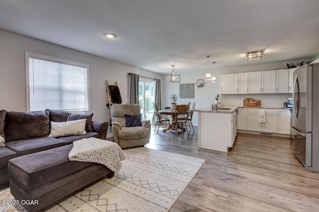 715 Wilson St, Webb City, MO 64870 - living room featuring a textured ceiling and light wood-type flooring