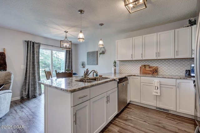 715 Wilson St, Webb City, MO 64870 - kitchen featuring a peninsula, white cabinets, light wood-style floors, and a textured ceiling