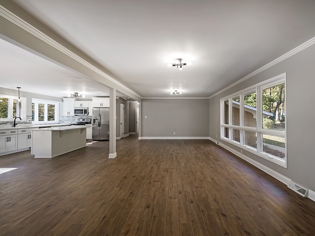 unfurnished living room with dark hardwood / wood-style flooring, sink, and crown molding