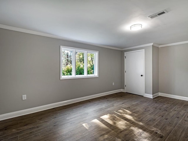 spare room with ornamental molding and dark wood-type flooring