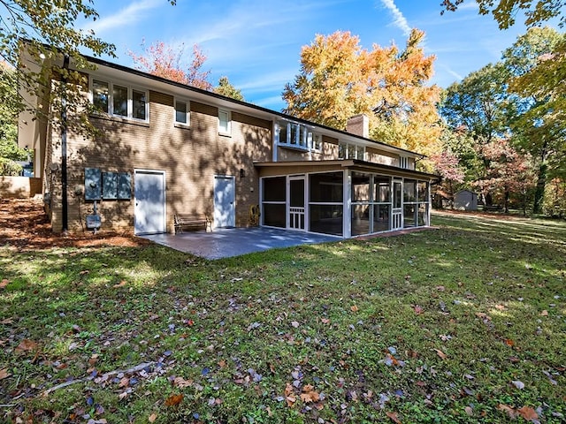 back of house featuring a patio, a yard, and a sunroom