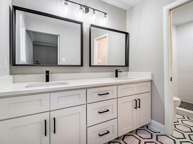 bathroom featuring vanity, a tile shower, and toilet