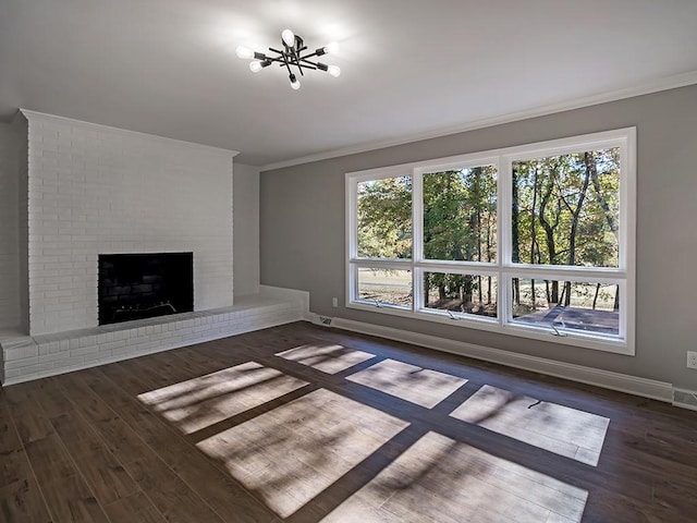 unfurnished living room featuring crown molding, dark wood-type flooring, and a brick fireplace