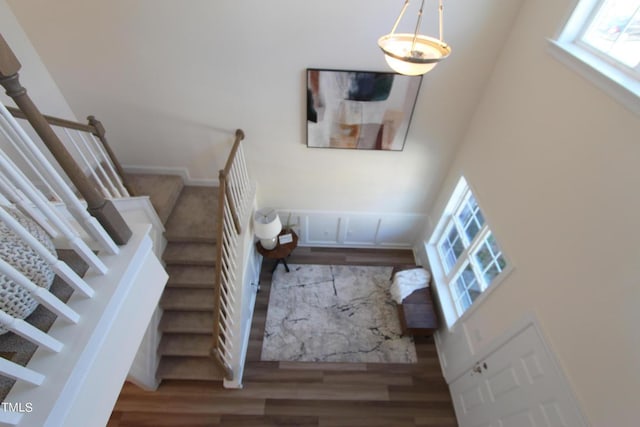 stairs featuring hardwood / wood-style floors and a high ceiling