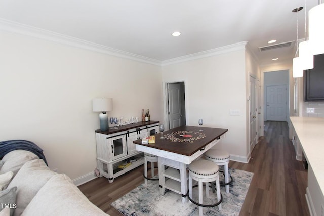 dining area with ornamental molding and dark hardwood / wood-style floors