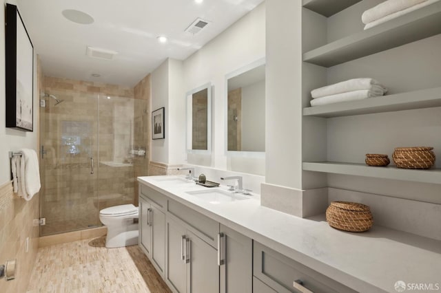 bathroom with toilet, wood-type flooring, vanity, and a shower with shower door