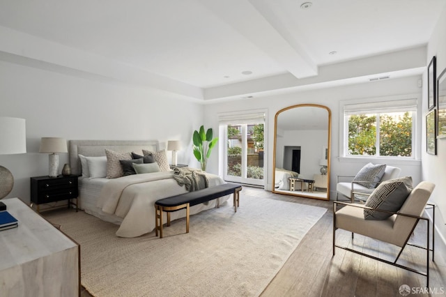 bedroom with beam ceiling and hardwood / wood-style flooring