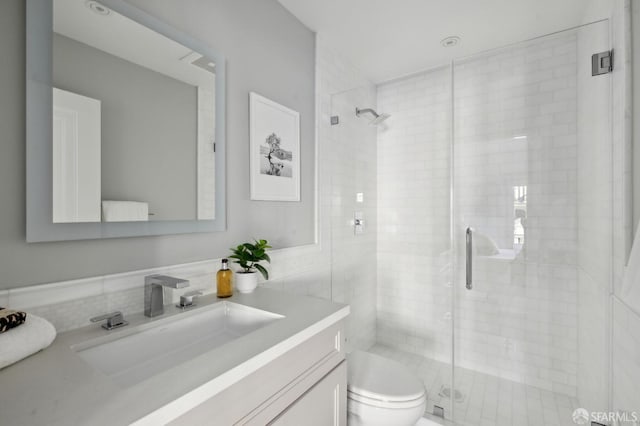 bathroom featuring vanity, an enclosed shower, and toilet