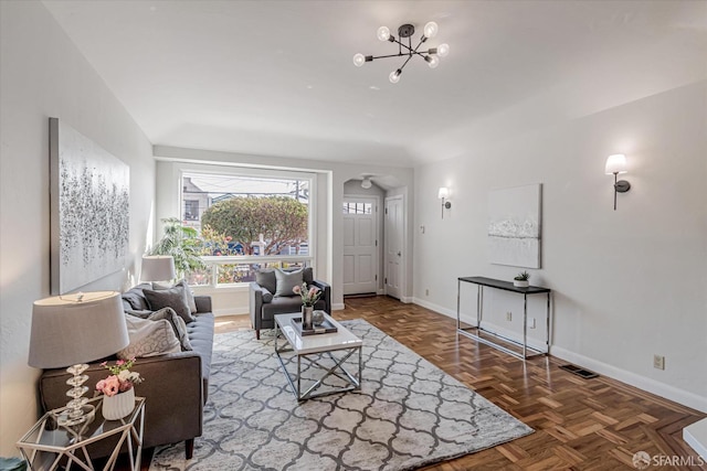 living room with a notable chandelier, visible vents, and baseboards