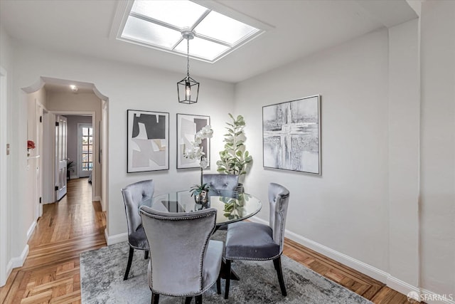 dining area featuring baseboards and a skylight