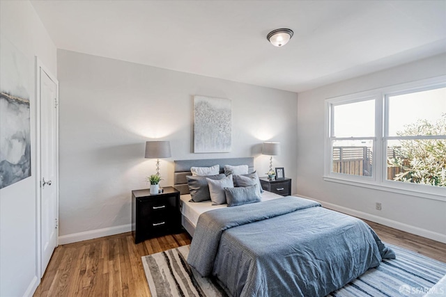 bedroom featuring baseboards and wood finished floors