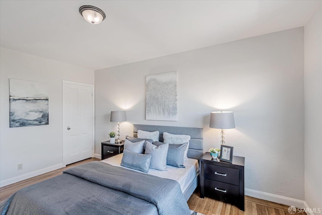 bedroom with baseboards and wood finished floors