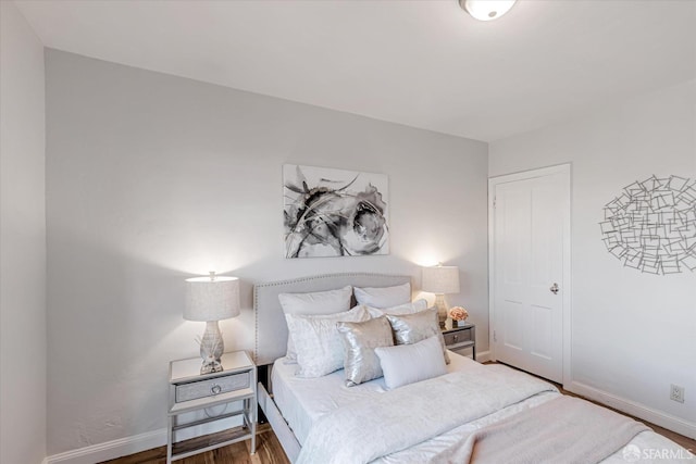 bedroom with baseboards and wood finished floors