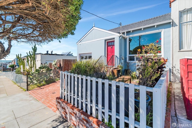 ranch-style home with a fenced front yard and stucco siding